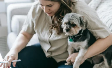 woman-holding-small-dog-on-couch